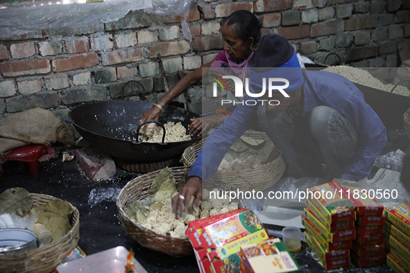 Workers prepare ''Joynagar Moa of West Bengal,'' an Indian sweet made with folk rice mixed with date molasses, inside a workshop at Jayanaga...