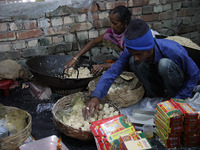 Workers prepare ''Joynagar Moa of West Bengal,'' an Indian sweet made with folk rice mixed with date molasses, inside a workshop at Jayanaga...