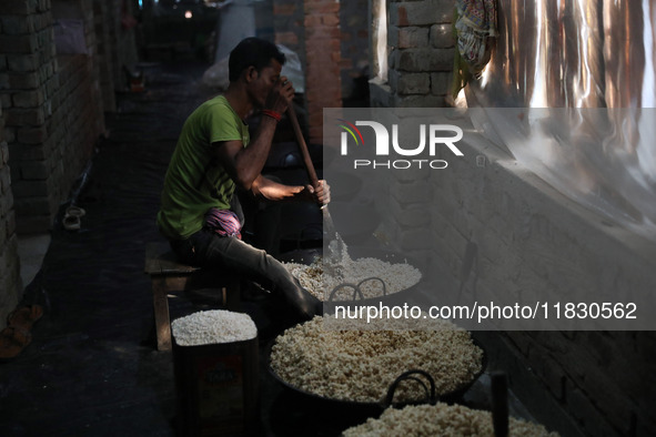 A worker prepares ''Joynagar Moa of West Bengal,'' an Indian sweet made with folk rice mixed with date molasses, inside a workshop at Jayana...