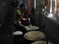 A worker prepares ''Joynagar Moa of West Bengal,'' an Indian sweet made with folk rice mixed with date molasses, inside a workshop at Jayana...