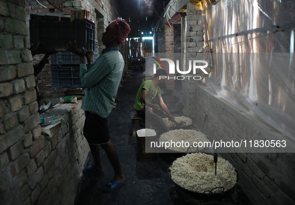 Workers prepare ''Joynagar Moa of West Bengal,'' an Indian sweet made with folk rice mixed with date molasses, inside a workshop at Jayanaga...