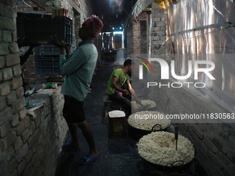 Workers prepare ''Joynagar Moa of West Bengal,'' an Indian sweet made with folk rice mixed with date molasses, inside a workshop at Jayanaga...