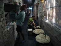 Workers prepare ''Joynagar Moa of West Bengal,'' an Indian sweet made with folk rice mixed with date molasses, inside a workshop at Jayanaga...