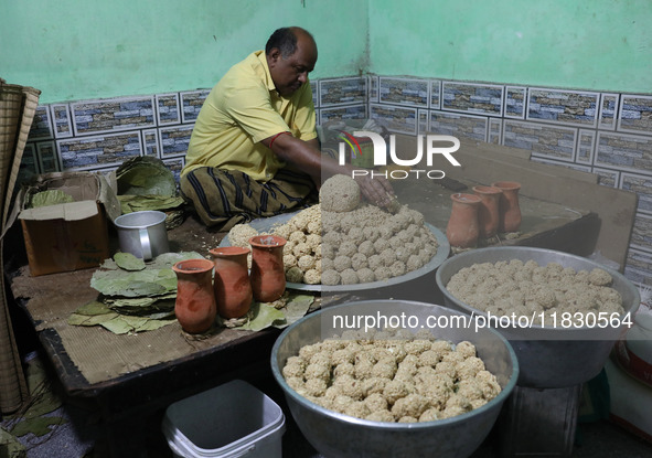 A man prepares ''Joynagar Moa of West Bengal'' (an Indian sweet) made with folk rice mixed with date molasses inside a workshop at Jayanagar...