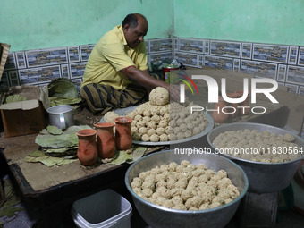 A man prepares ''Joynagar Moa of West Bengal'' (an Indian sweet) made with folk rice mixed with date molasses inside a workshop at Jayanagar...