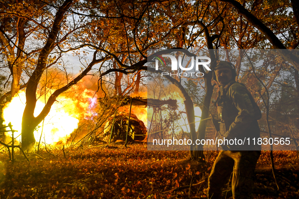 An artilleryman of the Khyzhak Patrol Police Special Unit fires a howitzer while on a combat mission at the positions in Donetsk region, eas...