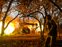 An artilleryman of the Khyzhak Patrol Police Special Unit fires a howitzer while on a combat mission at the positions in Donetsk region, eas...