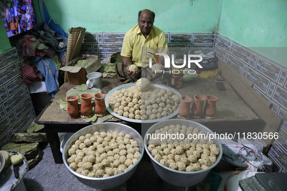 A man prepares ''Joynagar Moa of West Bengal'' (an Indian sweet) made with folk rice mixed with date molasses inside a workshop at Jayanagar...