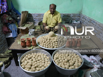 A man prepares ''Joynagar Moa of West Bengal'' (an Indian sweet) made with folk rice mixed with date molasses inside a workshop at Jayanagar...