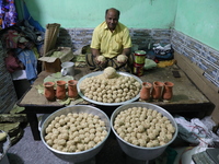 A man prepares ''Joynagar Moa of West Bengal'' (an Indian sweet) made with folk rice mixed with date molasses inside a workshop at Jayanagar...