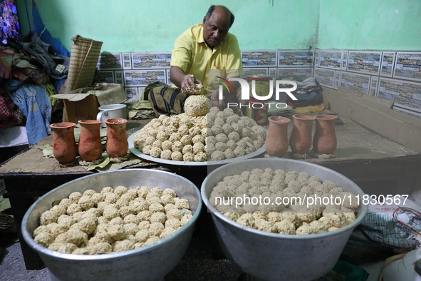 A man prepares ''Joynagar Moa of West Bengal'' (an Indian sweet) made with folk rice mixed with date molasses inside a workshop at Jayanagar...