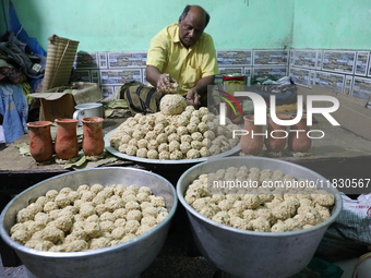 A man prepares ''Joynagar Moa of West Bengal'' (an Indian sweet) made with folk rice mixed with date molasses inside a workshop at Jayanagar...