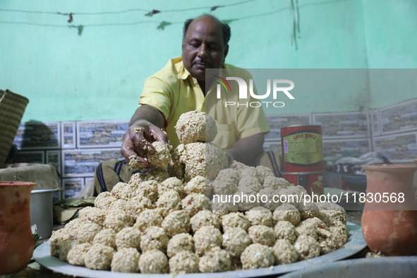 A man prepares ''Joynagar Moa of West Bengal'' (an Indian sweet) made with folk rice mixed with date molasses inside a workshop at Jayanagar...