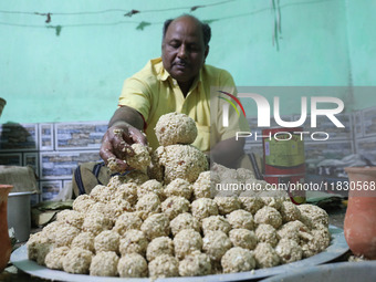 A man prepares ''Joynagar Moa of West Bengal'' (an Indian sweet) made with folk rice mixed with date molasses inside a workshop at Jayanagar...