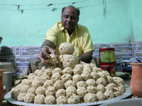 A man prepares ''Joynagar Moa of West Bengal'' (an Indian sweet) made with folk rice mixed with date molasses inside a workshop at Jayanagar...