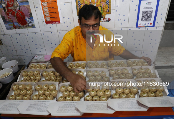 A man prepares ''Joynagar Moa of West Bengal'' (an Indian sweet) made with folk rice mixed with date molasses inside a workshop at Jayanagar...