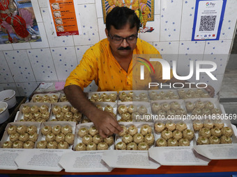 A man prepares ''Joynagar Moa of West Bengal'' (an Indian sweet) made with folk rice mixed with date molasses inside a workshop at Jayanagar...