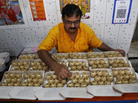 A man prepares ''Joynagar Moa of West Bengal'' (an Indian sweet) made with folk rice mixed with date molasses inside a workshop at Jayanagar...