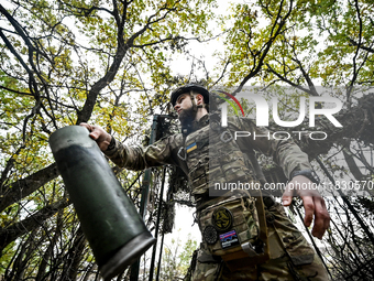 An artilleryman of the Khyzhak Patrol Police Special Unit holds an artillery shell case while on a combat mission at the positions in the Do...