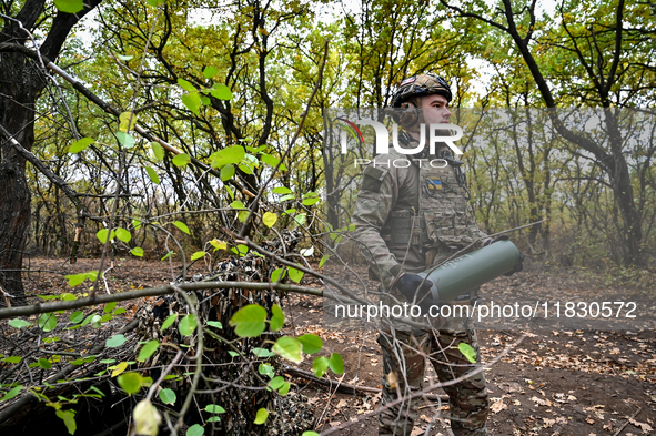 An artilleryman of the Khyzhak Patrol Police Special Unit holds an artillery shell case while on a combat mission at the positions in the Do...