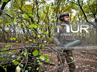 An artilleryman of the Khyzhak Patrol Police Special Unit holds an artillery shell case while on a combat mission at the positions in the Do...