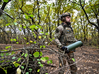 An artilleryman of the Khyzhak Patrol Police Special Unit holds an artillery shell case while on a combat mission at the positions in the Do...