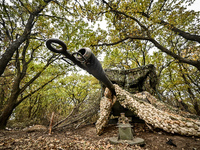 A howitzer is under a camouflage net as the artillerymen of the Khyzhak Patrol Police Special Unit are on a combat mission at the positions...