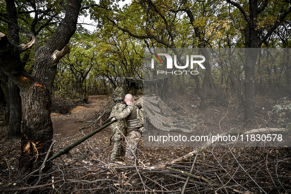 Artillerymen of the Khyzhak Patrol Police Special Unit clean the barrel of a howitzer while on a combat mission at the positions in Donetsk...