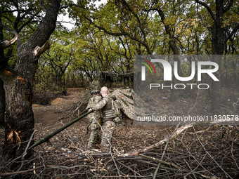 Artillerymen of the Khyzhak Patrol Police Special Unit clean the barrel of a howitzer while on a combat mission at the positions in Donetsk...