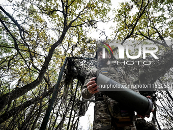 An artilleryman of the Khyzhak Patrol Police Special Unit holds an artillery shell case while on a combat mission at the positions in the Do...