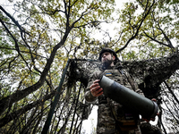 An artilleryman of the Khyzhak Patrol Police Special Unit holds an artillery shell case while on a combat mission at the positions in the Do...