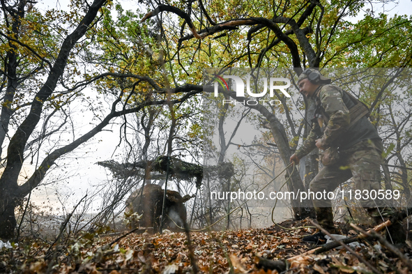 An artilleryman of the Khyzhak Patrol Police Special Unit fires a howitzer while on a combat mission at the positions in Donetsk region, eas...