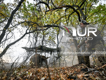 An artilleryman of the Khyzhak Patrol Police Special Unit fires a howitzer while on a combat mission at the positions in Donetsk region, eas...