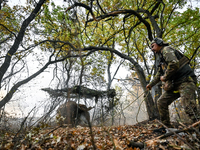 An artilleryman of the Khyzhak Patrol Police Special Unit fires a howitzer while on a combat mission at the positions in Donetsk region, eas...