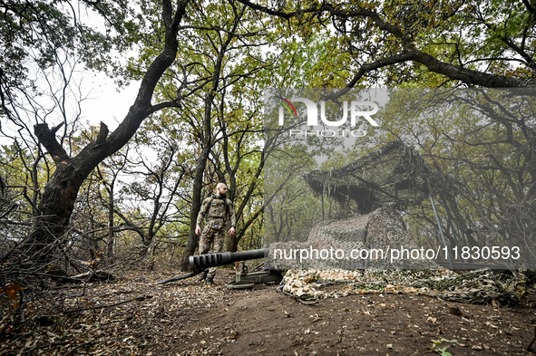 An artilleryman of the Khyzhak Patrol Police Special Unit stands by a howitzer covered with a camouflage net while on a combat mission at th...