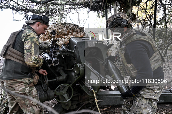 Artillerymen of the Khyzhak Patrol Police Special Unit load a howitzer while on a combat mission at the positions in Donetsk region, eastern...