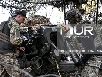 Artillerymen of the Khyzhak Patrol Police Special Unit load a howitzer while on a combat mission at the positions in Donetsk region, eastern...