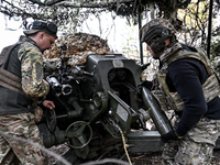 Artillerymen of the Khyzhak Patrol Police Special Unit load a howitzer while on a combat mission at the positions in Donetsk region, eastern...