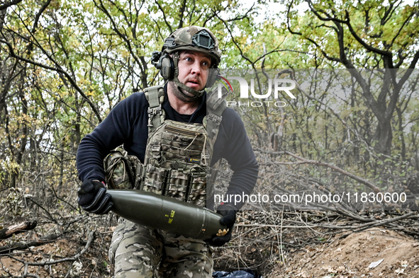 An artilleryman of the Khyzhak Patrol Police Special Unit holds an artillery shell while on a combat mission at the positions in the Donetsk...