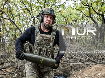 An artilleryman of the Khyzhak Patrol Police Special Unit holds an artillery shell while on a combat mission at the positions in the Donetsk...