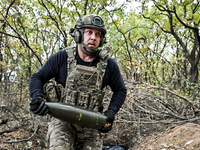 An artilleryman of the Khyzhak Patrol Police Special Unit holds an artillery shell while on a combat mission at the positions in the Donetsk...