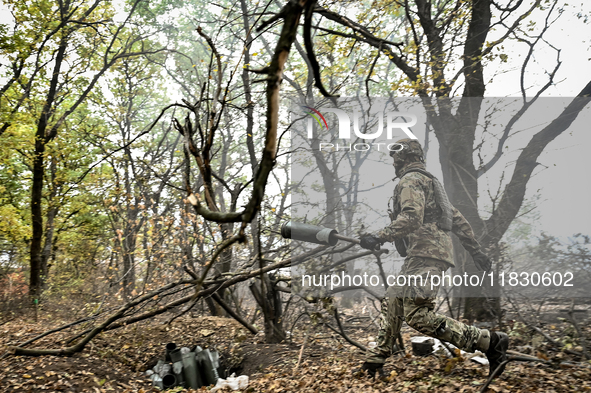 An artilleryman of the Khyzhak Patrol Police Special Unit disposes of an artillery shell case while on a combat mission at the positions in...