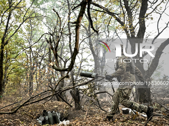 An artilleryman of the Khyzhak Patrol Police Special Unit disposes of an artillery shell case while on a combat mission at the positions in...