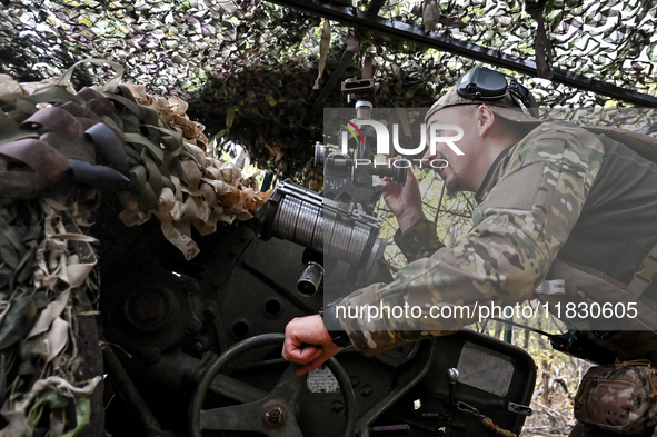 An artilleryman of the Khyzhak Patrol Police Special Unit aims a howitzer while on a combat mission at the positions in Donetsk region, east...