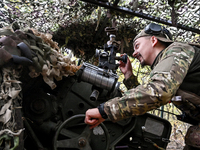 An artilleryman of the Khyzhak Patrol Police Special Unit aims a howitzer while on a combat mission at the positions in Donetsk region, east...