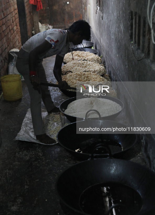 A worker prepares ''Joynagar Moa of West Bengal,'' an Indian sweet made with folk rice mixed with date molasses, inside a workshop at Jayana...