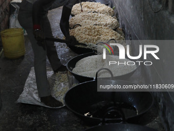 A worker prepares ''Joynagar Moa of West Bengal,'' an Indian sweet made with folk rice mixed with date molasses, inside a workshop at Jayana...