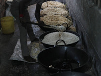 A worker prepares ''Joynagar Moa of West Bengal,'' an Indian sweet made with folk rice mixed with date molasses, inside a workshop at Jayana...