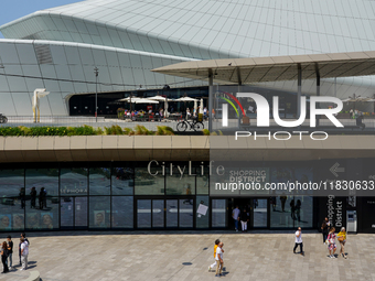 A dynamic atmosphere exists in front of an entrance to the CityLife Shopping District in Milan, Italy, on May 27, 2023. (