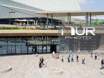 A dynamic atmosphere exists in front of an entrance to the CityLife Shopping District in Milan, Italy, on May 27, 2023. (